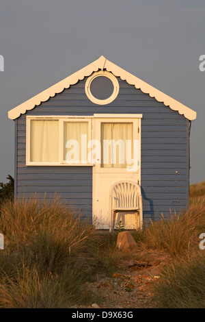 chaise placée à l'extérieur de la hutte de plage bleue en se prélassant dans la lumière du soir à Hengistbury Head, Mudeford Spit, Christchurch, Dorset UK en juin Banque D'Images