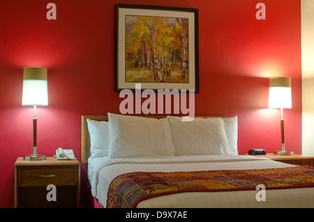 Une chambre d'hôtel milieu de gamme avec un lit tout frais, un bon éclairage et dynamique, la couleur des murs est présenté dans cette image. Banque D'Images