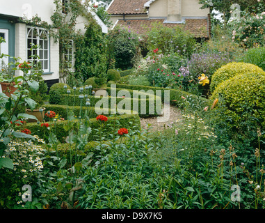 English Chalet jardin avec allée de graviers et de buis taillés et faible couverture d'or ronde privet arbustes Banque D'Images