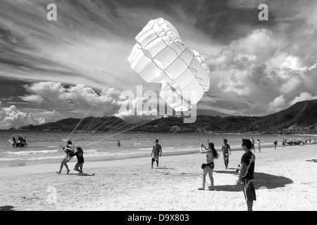 PATONG Beach, Phuket, Thaïlande 4 AOÛT 2011 : un opérateur du parachute ascensionnel et le client touche vers le bas, sur la plage de Patong, après un tour. Banque D'Images