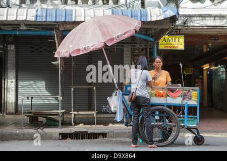 Une rue vendour fruits côtelettes pour un client sur Banglamphu Khaosan Road,, Bangkok, Thaïlande, Bangkok. Banque D'Images