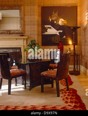 Plateau en verre table de salle à manger et chaises capitonnées dans grand salle à manger avec grande peinture et tapis à motifs de couleurs vives Banque D'Images