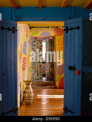 Voir à travers les portes bleues à grand pot poterie colorée dans la salle à manger avec parquet et murs peint décorative Banque D'Images