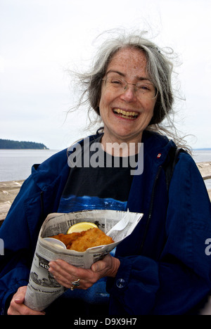 Happy female client commande énorme poisson-frites en cône journal jetée de pêche découverte stand alimentaire Banque D'Images