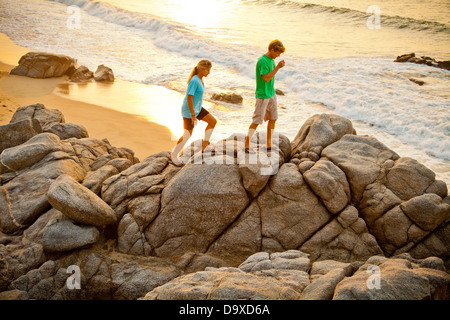 Couple hiking on beach rocks Banque D'Images