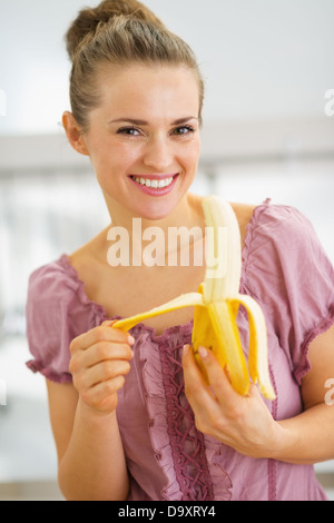 Jeune femme au foyer dans la cuisine de la banane de déroulage Banque D'Images