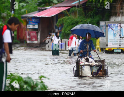 Cette expérience s, de Davao. 28 juin 2013. Les résidents philippins comme manoeuvres ils essayer de passer dans une route inondée par une cause de pluie Averse lourde à Davao City, Philippines du Sud, le 28 juin 2013. Selon l'atmosphère géophysiques et astronomiques des Philippines Services Administration (PAGASA), Storm Signal numéro un est relevé dans les régions de Visayas et Mindanao comme dépression tropicale "Gorio" entre dans le territoire des Philippines. Credit : Eli Ritchie Tongo/Alamy Live News Banque D'Images