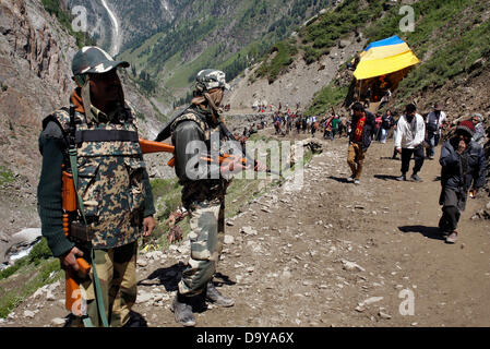 Baltal, Cachemire indien 28 Juin 2013.Les policiers indiens montent la garde comme dévots hindous à pied durant leur pèlerinage de Baltal Camp de base à la Sainte Grotte Amarnath Shrine, à Baltal . Chaque année, des centaines de milliers de pèlerins à travers les montagnes perfides en révolte-déchiré le Cachemire, le long de rivières glacées, des glaciers et des lacs gelés, des laissez-passer pour atteindre l'Amarnath grotte, située à une altitude de 3 857 mètres (12 729 pieds), où un Shiva Lingam, une stalagmite de glace en forme de phallus et symbolisant le dieu hindou Shiva, est synonyme de culte. (Sofi Suhail/ Alamy Live News) Banque D'Images