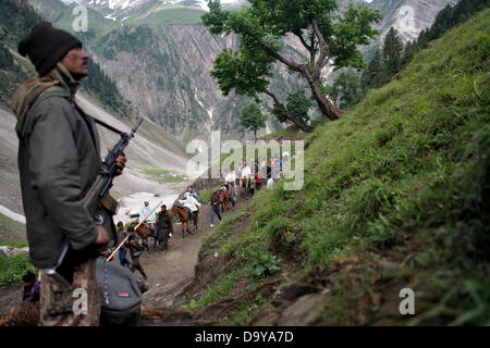 Baltal, Cachemire indien 28 Juin 2013.Un policier indien monte la garde comme dévots hindous à pied durant leur pèlerinage de Baltal Camp de base à la Sainte Grotte Amarnath Shrine, à Baltal . Chaque année, des centaines de milliers de pèlerins à travers les montagnes perfides en révolte-déchiré le Cachemire, le long de rivières glacées, des glaciers et des lacs gelés, des laissez-passer pour atteindre l'Amarnath grotte, située à une altitude de 3 857 mètres (12 729 pieds), où un Shiva Lingam, une stalagmite de glace en forme de phallus et symbolisant le dieu hindou Shiva, est synonyme de culte. (Sofi Suhail/ Alamy Live News) Banque D'Images