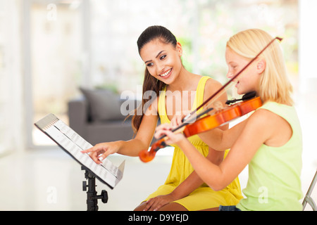 Preteen girl jouer du violon sous les instructions du professeur de musique Banque D'Images