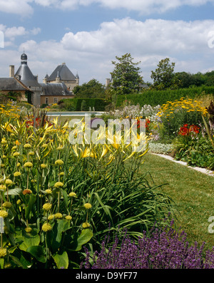 Les hémérocalles jaunes et Jérusalem sage en grandes frontières herbacées sur chaque côté de large chemin dans jardin de château français Banque D'Images