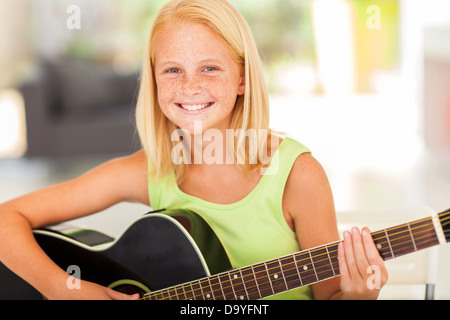 Happy girl avant la pratique de la guitare à la maison Banque D'Images