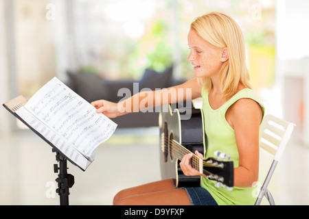 Preteen girl talentueux qui joue de la guitare avec les accords Banque D'Images