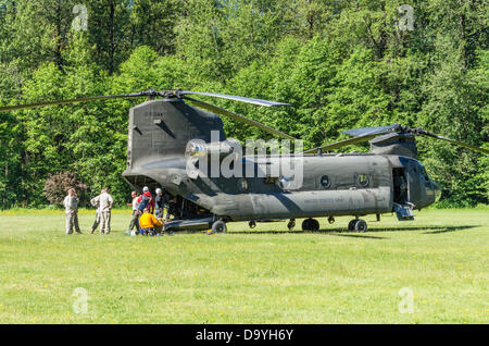 De l'Oregon, États-Unis, le 28 juin 2013. Un hélicoptère Chinook de l'Armée US atterrit à un terrain de baseball de l'école dans la région de Welches, Oregon pour charger une équipe de recherche et de sauvetage pour aider à retrouver un grimpeur sur Mt. le capot. Banque D'Images