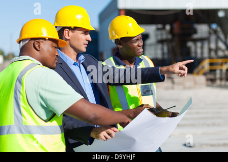 Groupe d'architecte et de travailleurs de la construction sur site avec blue print Banque D'Images