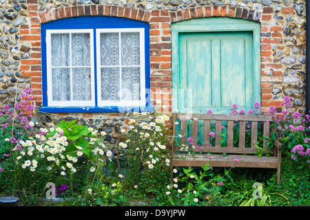 Flint face cottage avec fleurs d'été et en bois, banc de jardin, Norfolk, Angleterre, juin Banque D'Images