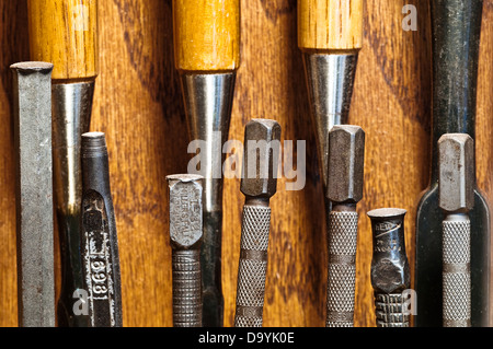 Le travail du bois outils à main, y compris les alênes, poinçons, burins et fixe affiché dans une armoire murale. Banque D'Images