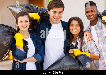 Cheerful young volunteers avec sac à déchets après avoir nettoyé les rues Banque D'Images