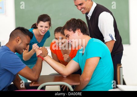 Les adolescents du secondaire Arm wrestling in classroom Banque D'Images