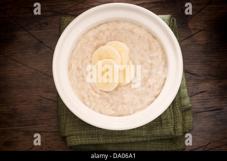 Bol de porridge garni de tranches de banane à partir de ci-dessus. Banque D'Images