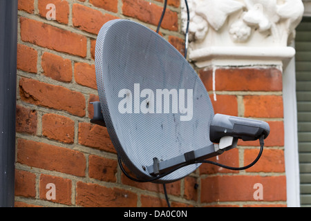 Antenne satellite altérés sur le côté d'un immeuble Banque D'Images