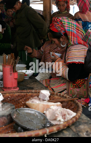 Les femmes Hmong fleur tribal traditionnel manger la nourriture et boire le thé au marché de Bac Ha, au Vietnam, en Asie du sud-est Banque D'Images