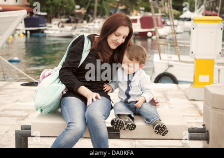 La mère et le fils assis dans Harbour Banque D'Images