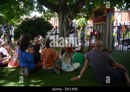 Les enfants de l'école primaire traditionnelle regarder un Punch and Judy show à leur fête scolaire annuel Banque D'Images