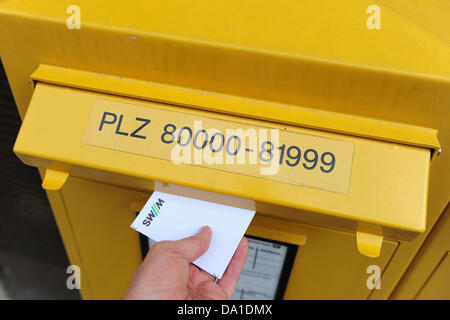 (ILLUSTRATION) une illustration photo datée du 21 juin 2013 montre un homme mettre une lettre dans une boîte à lettres à Munich, Allemagne, 21 juin 2013. Photo : MARC MUELLER Banque D'Images