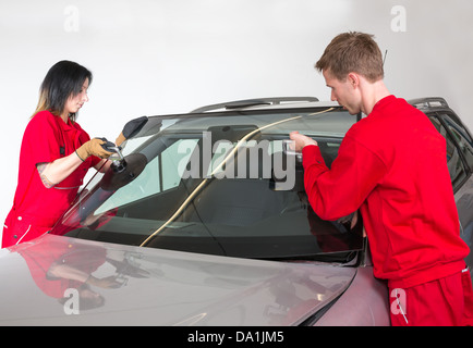 Glazier dépose du pare-brise ou le pare-brise d'une voiture Banque D'Images