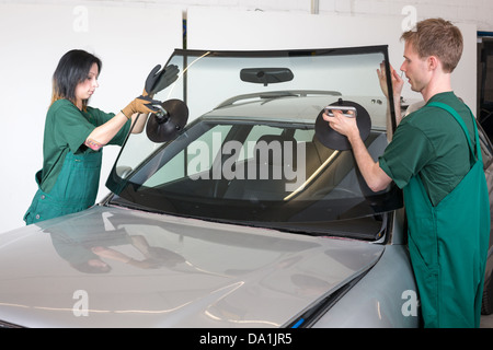 Glazier dépose du pare-brise ou le pare-brise d'une voiture Banque D'Images