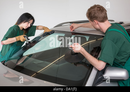 Glazier dépose du pare-brise ou le pare-brise d'une voiture Banque D'Images