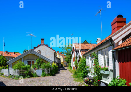 Vue sur la rue de la vieille ville avec de petites maisons en bois dans la ville suédoise de Kalmar par la côte de la mer Baltique. Banque D'Images