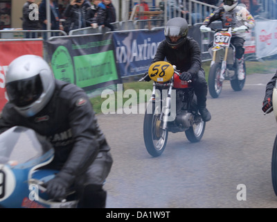 Cette image capture un moment pendant une course de moto, mettant en vedette la Ducati No58 sur la ligne de départ. La photo souligne la vitesse et l'excitation du sport, avec la Ducati bien en vue dans un contexte de course. Banque D'Images