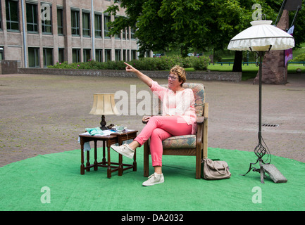 Femme assise sur une chaise et de pointing Banque D'Images