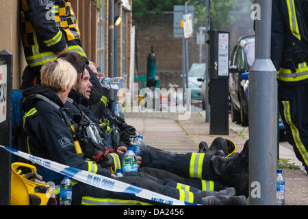 Londres, Royaume-Uni. 1er juillet 2013. Les pompiers reste sur la chaussée après avoir combattu un incendie au pneu roue & Co, Kensal Green. Une bouteille de gaz, qui peut être vu dans l'arrière-plan a été retiré de la les lieux. Crédit : Paul Davey/Alamy Live News Banque D'Images