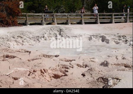 Les touristes clôture en bois debout regardant en boue bouillonnante d'évent Pot Peinture Fontaine, Yellowstone Geyser Basin, hotspot, USA Banque D'Images