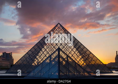 Coucher de soleil derrière la pyramide de verre du musée du Louvre, Paris France Banque D'Images