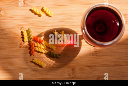 La vie toujours avec des pâtes colorées et glasss de vin rouge bouteille colorée et dans l'éclairage naturel. Banque D'Images