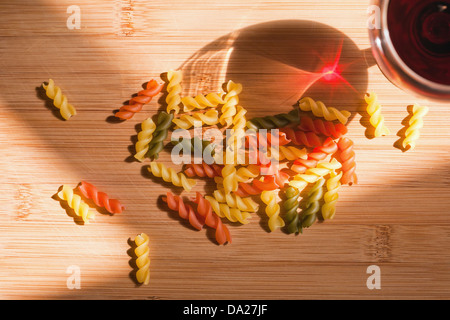 La vie toujours avec des pâtes colorées et glasss de vin rouge bouteille colorée et dans l'éclairage naturel. Banque D'Images