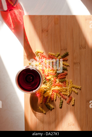 La vie toujours avec des pâtes colorées et glasss de vin rouge bouteille colorée et dans l'éclairage naturel. Banque D'Images