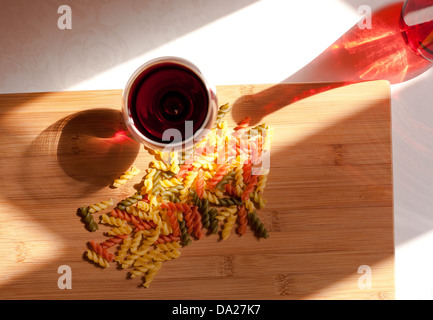 La vie toujours avec des pâtes colorées et glasss de vin rouge bouteille colorée et dans l'éclairage naturel. Banque D'Images
