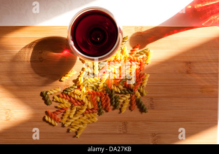 La vie toujours avec des pâtes colorées et glasss de vin rouge bouteille colorée et dans l'éclairage naturel. Banque D'Images