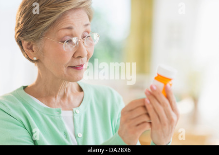 Senior woman reading medicine label Banque D'Images