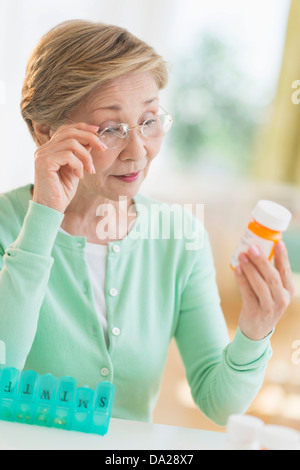 Senior woman reading medicine label Banque D'Images