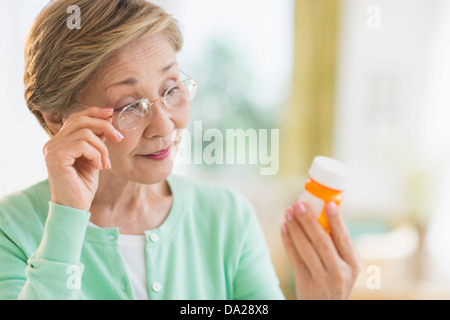 Senior woman reading medicine label Banque D'Images