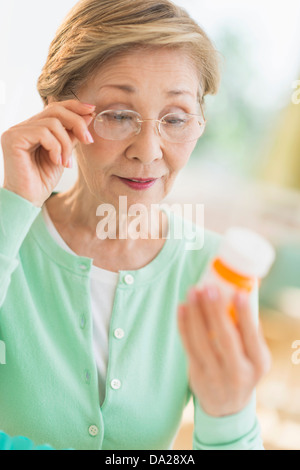 Senior woman reading medicine label Banque D'Images