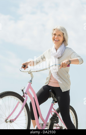 Senior woman riding bicycle Banque D'Images