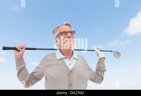 Senior man holding golf club Banque D'Images