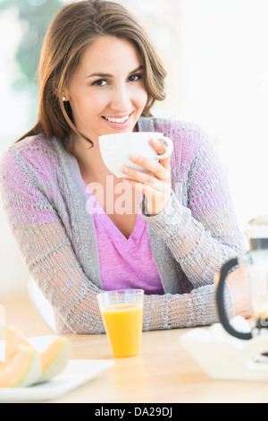 Portrait de jeune femme à boire le thé à table Banque D'Images